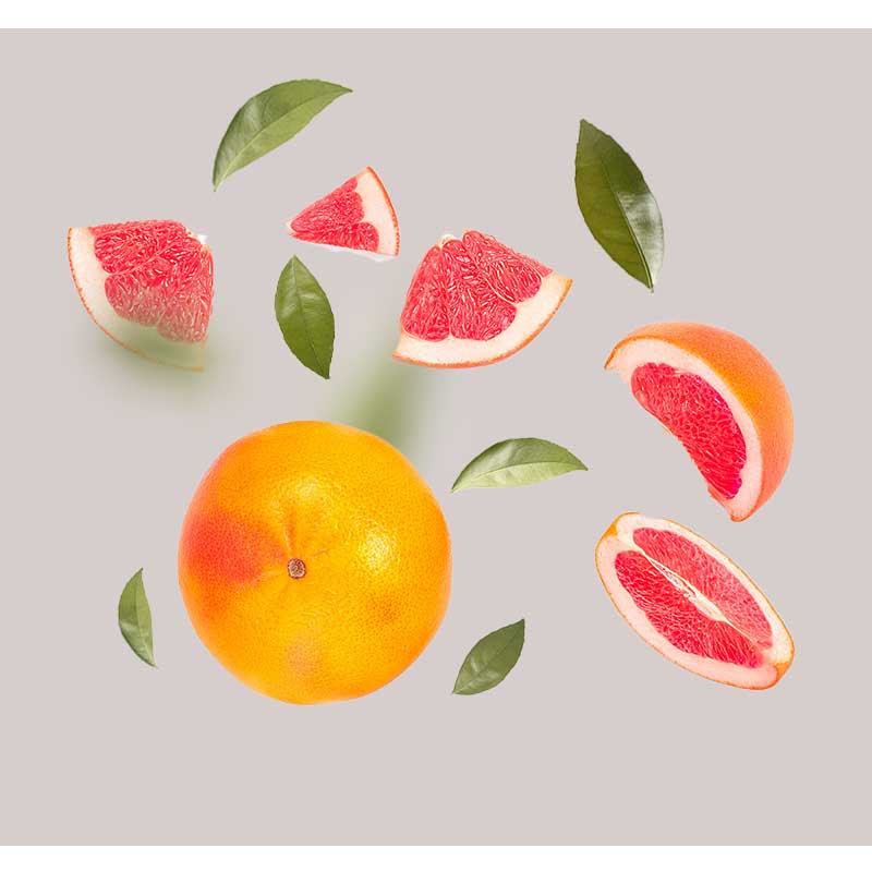 grapefruit-extrakt Grapefruit und Grapefruitstücke mit grünen Blättern, symbolisierend die frischen Inhaltsstoffe des Tri-Peelings von RAU Cosmetics, das für sensible Haut zur Tiefenreinigung und Anti-Aging entwickelt wurde.