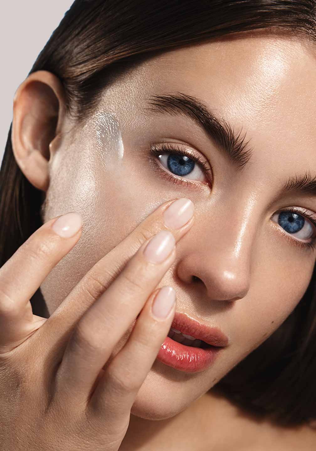 Frau mit glatter Haut, die RAU Cosmetics Anti-Rötungsserum aufträgt, betont natürliche Schönheit und Hautpflege.